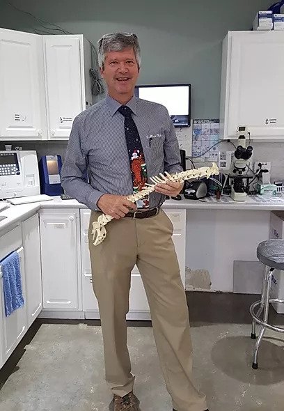 5 dr mulch holding an example spine and posing in vet office