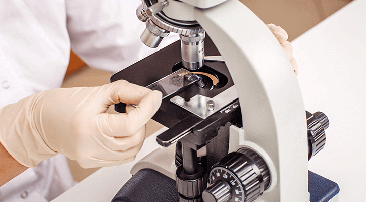 In-House-Lab technician using microscope to look at sample in in-house lab